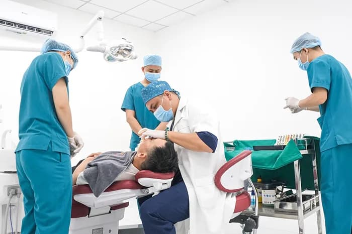 Kíp phẫu thuật bốn người thực hiện ca điều trị trong phòng vô trùng